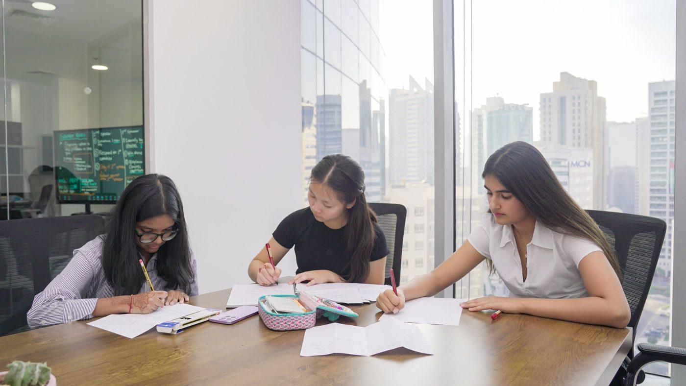 Students drafting at a conference table during class